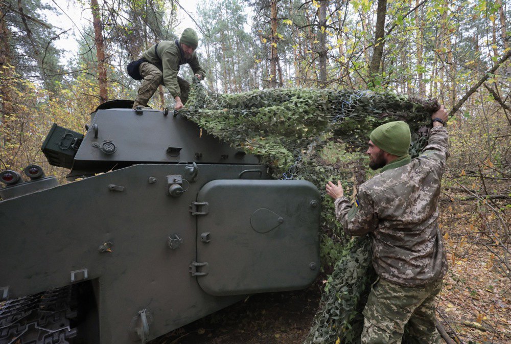 Військовослужбовці 154-ї окремої механізованої бригади прикривають маскувальною сіткою САУ 2С1 «Гвоздика» на передовій у Харківській області, 09 жовтня 2024 р.