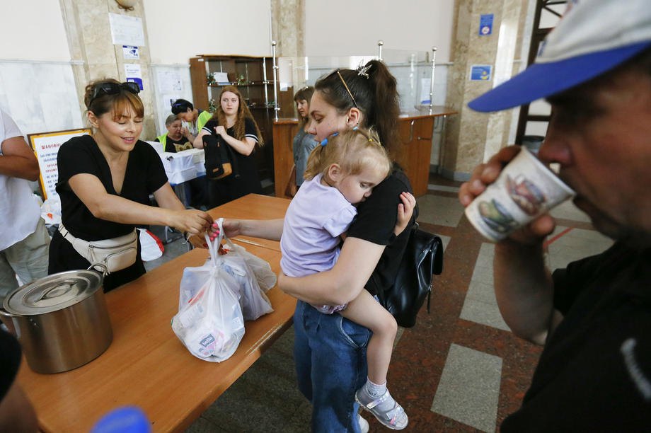 Переселенці з Миколаєва й родини, яким вдалося втекти з тимчасово окупованих територій, отримують допомогу на залізничному вокзалі Одеси, 2 червня 2022 року, перед тим як рушити на захід України або за кордон.